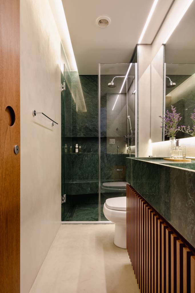 Apê pequeno tem home office verde e estiloso oculto na marcenaria. Projeto de COTA 760 Arquitetura.