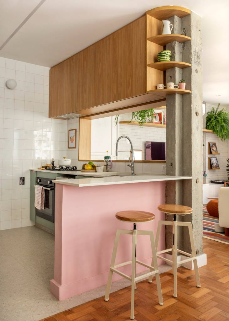 Neste apê, verde, rosa e terracota compõem cozinha com janela para a sala. Projeto de Raphael Assaf Arquitetura.