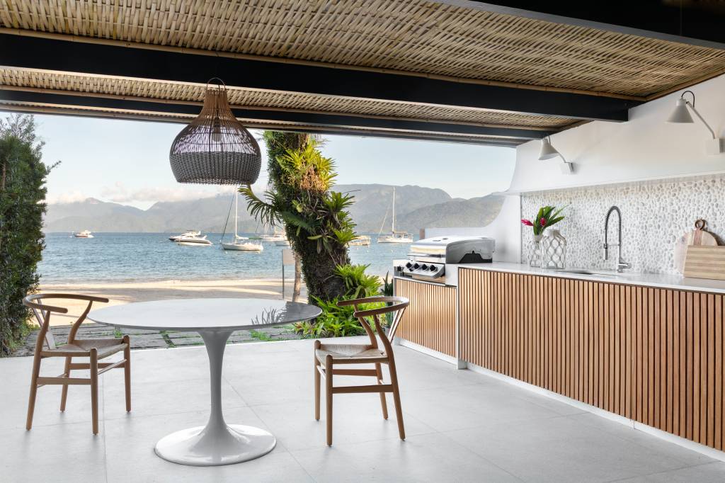 Telhado em bambu natural trançado cobre varanda gourmet de casa de praia