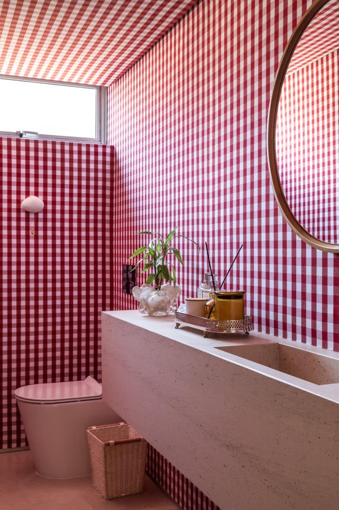 Além de muito design brasileiro, apê tem lavabo estiloso com xadrez vermelho. Projeto de ARQ+CO Studio.