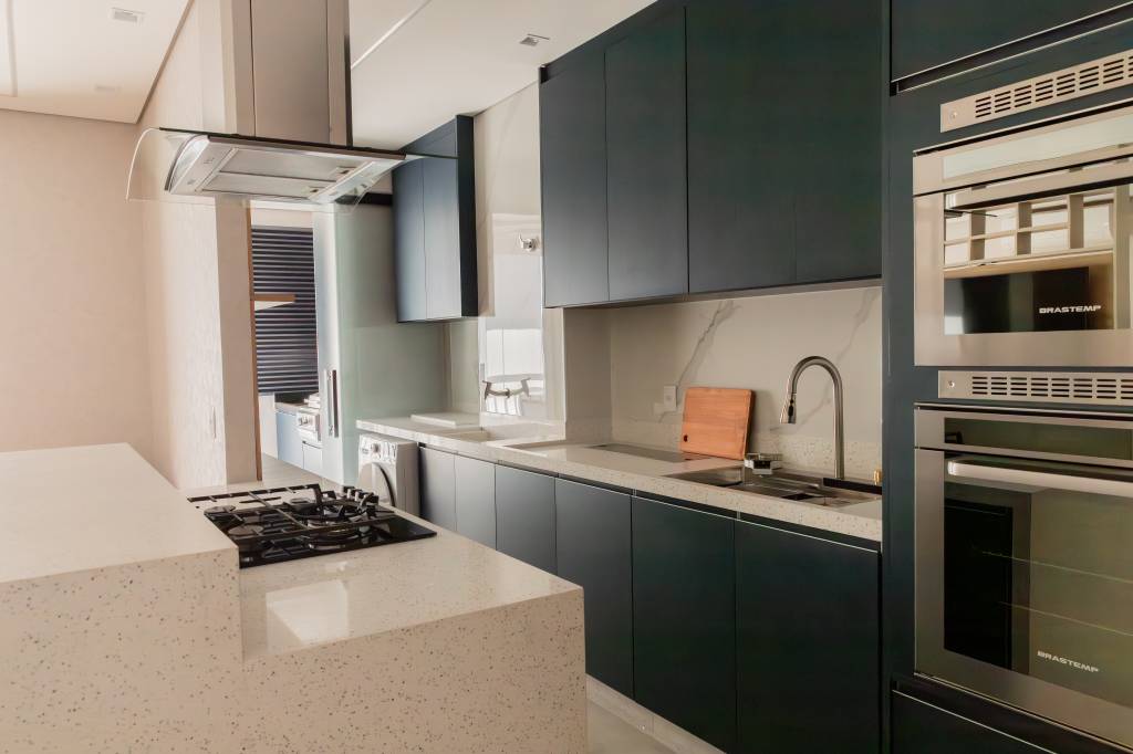 Apê de 86 m² tem varanda gourmet pequena com jardim vertical e churrasqueira elétrica. Projeto de Marcela Rocca.