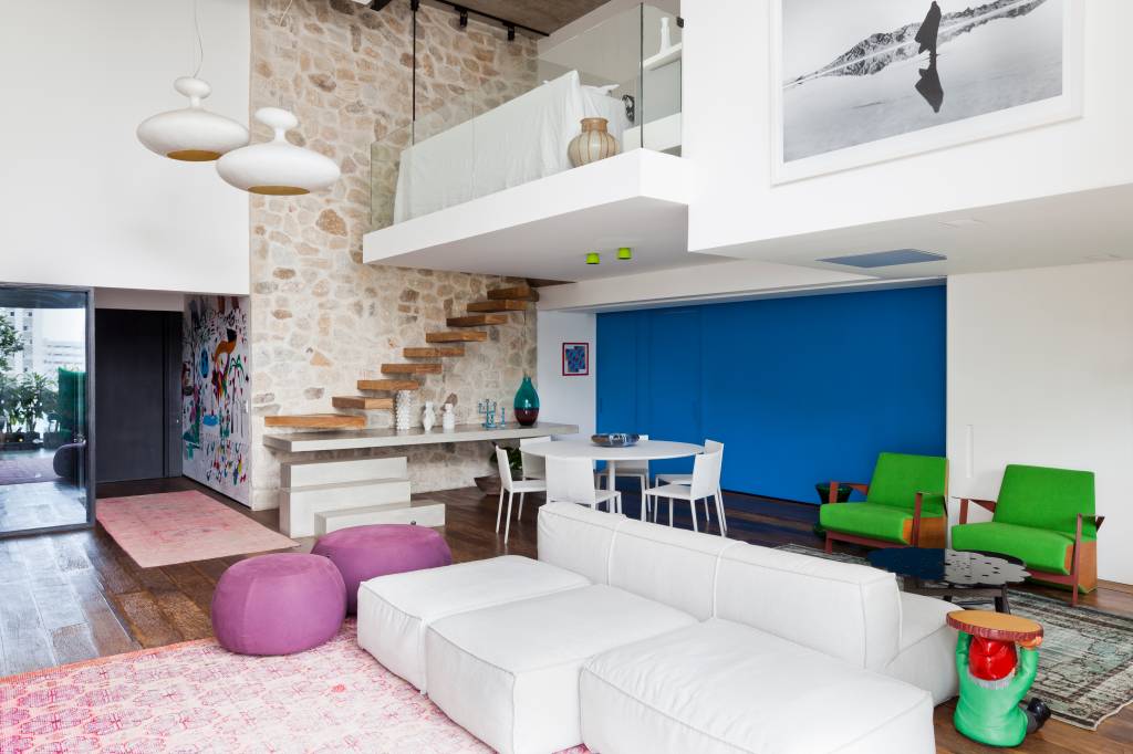 Cheio de estilo, apartamento moderno tem parede azul, parede de pedras e mezanino