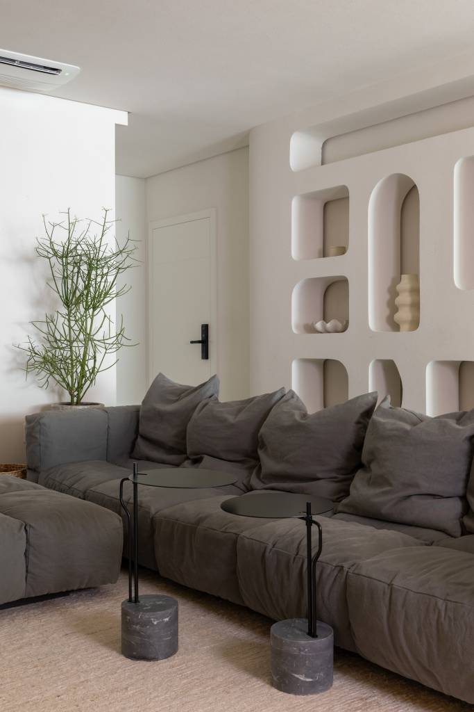 Inspirado na Grécia, apartamento praiano tem nichos na parede e tons areia. Projeto de Bo. Arch Studio.