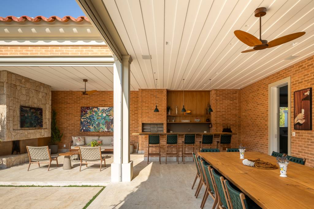 Tijolinhos, telhas de barro, madeira e mármore compõem casa em estilo toscano. Projeto de Rogério Luciani Arquitetura.