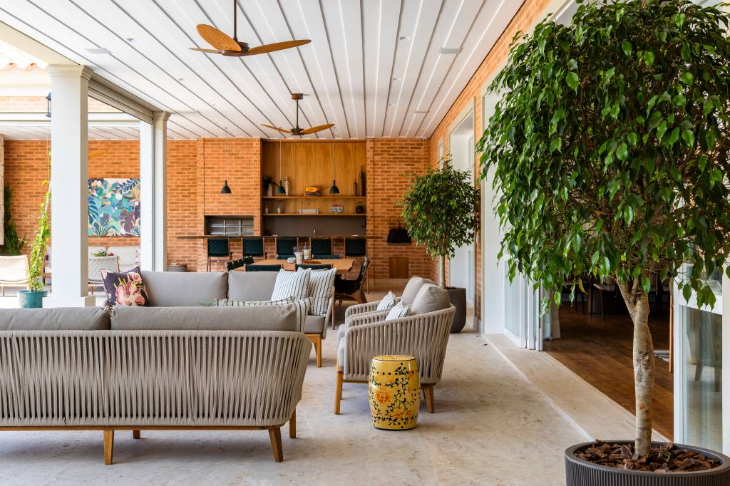 Tijolinhos, telhas de barro, madeira e mármore compõem casa em estilo toscano. Projeto de Rogério Luciani Arquitetura.