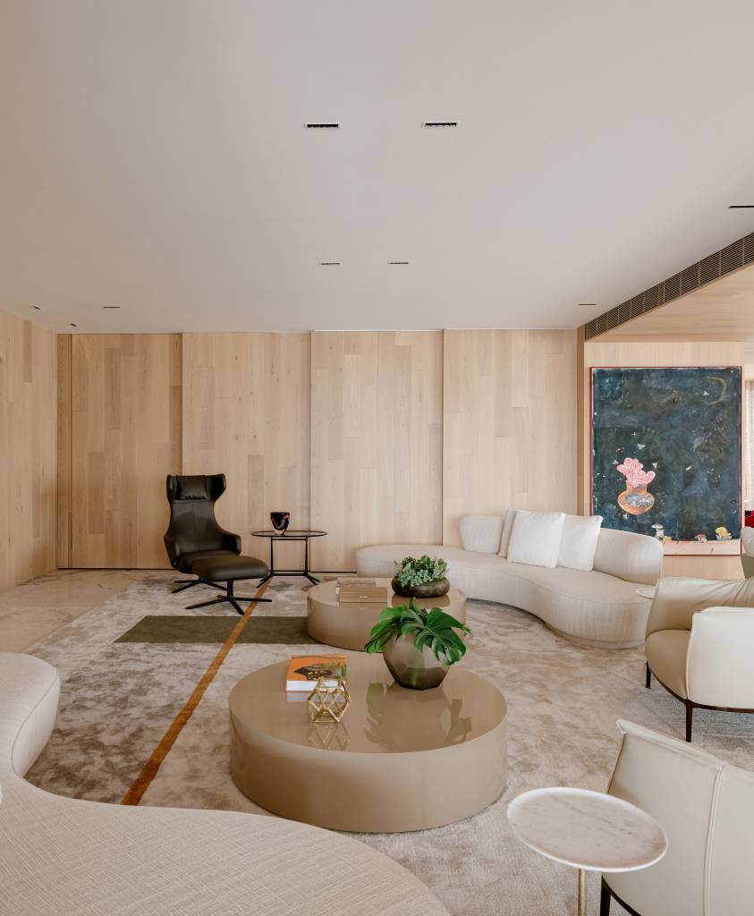 Apartamento amplo tem piso de mármore e painéis de madeira como divisórias. Projeto de DB Arquitetos.