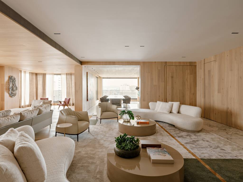 Apartamento amplo tem piso de mármore e painéis de madeira como divisórias. Projeto de DB Arquitetos.