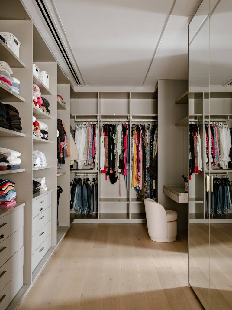 Apartamento amplo tem piso de mármore e painéis de madeira como divisórias. Projeto de DB Arquitetos.