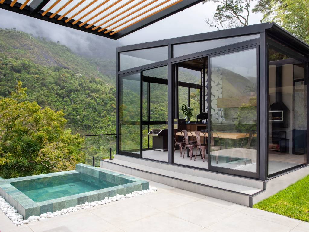 Jardineiras com Filodendros contornam as esquadrias desta casa no mato. Projeto de Felipe Rohen.