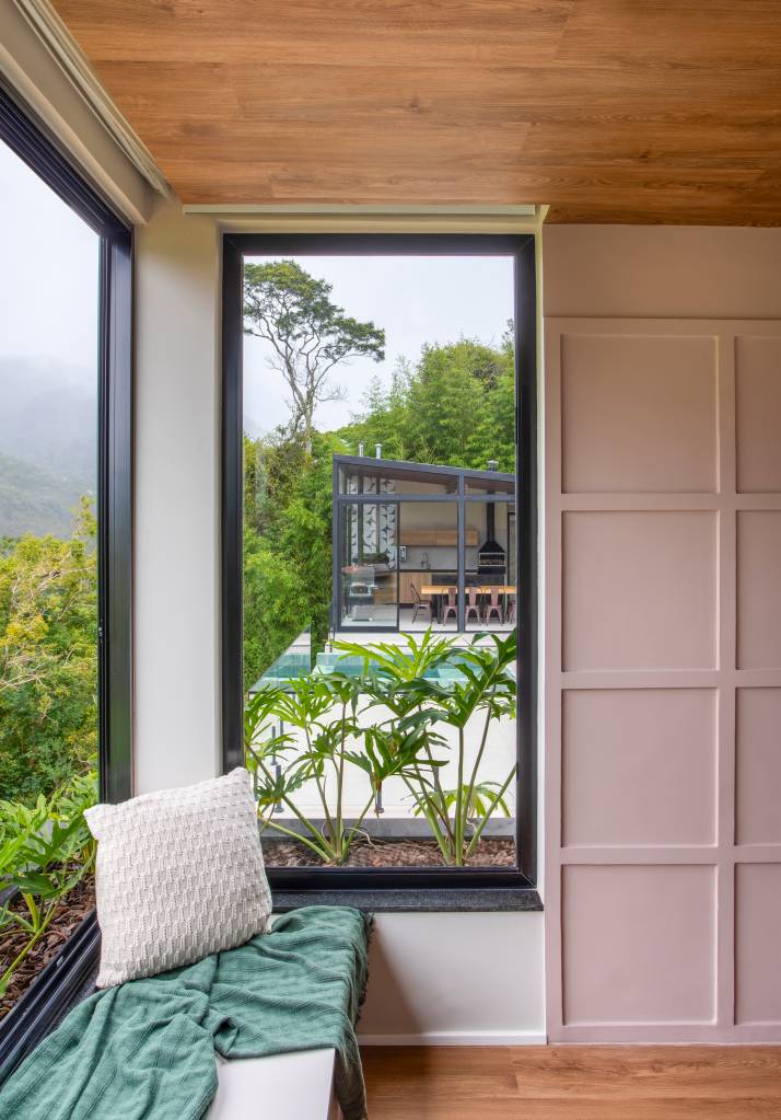 Jardineiras com Filodendros contornam as esquadrias desta casa no mato. Projeto de Felipe Rohen.