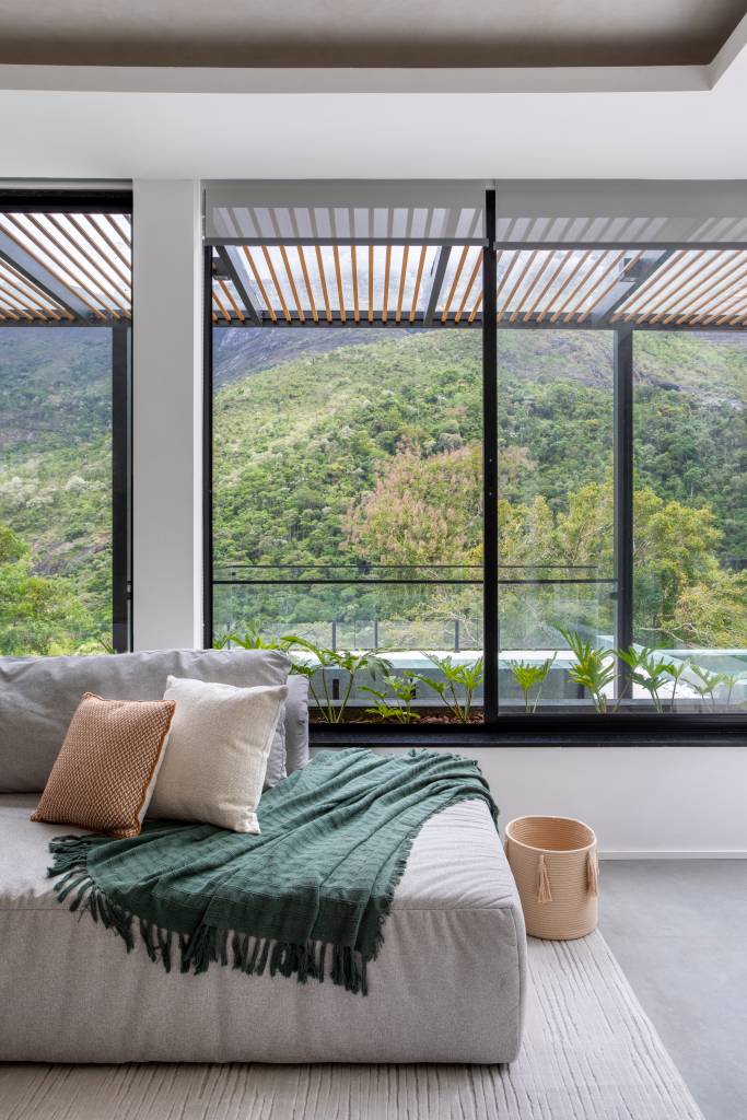 Jardineiras com Filodendros contornam as esquadrias desta casa no mato. Projeto de Felipe Rohen.