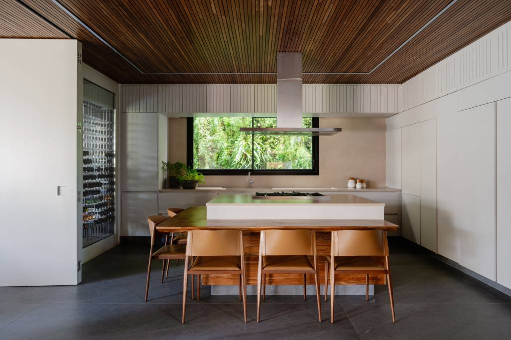 Casa de 880m² em São Paulo se integra ao jardim após ampla reforma. Projeto de Studio DWG. Espaço gourmet com adega