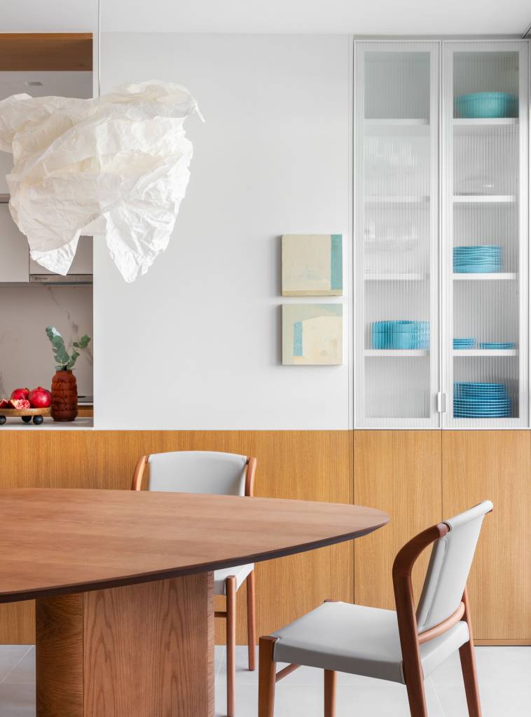 Escada de apê clean tem degraus e espelhos revestidos em quartzo cinza. Projeto de Rafael Ramos.