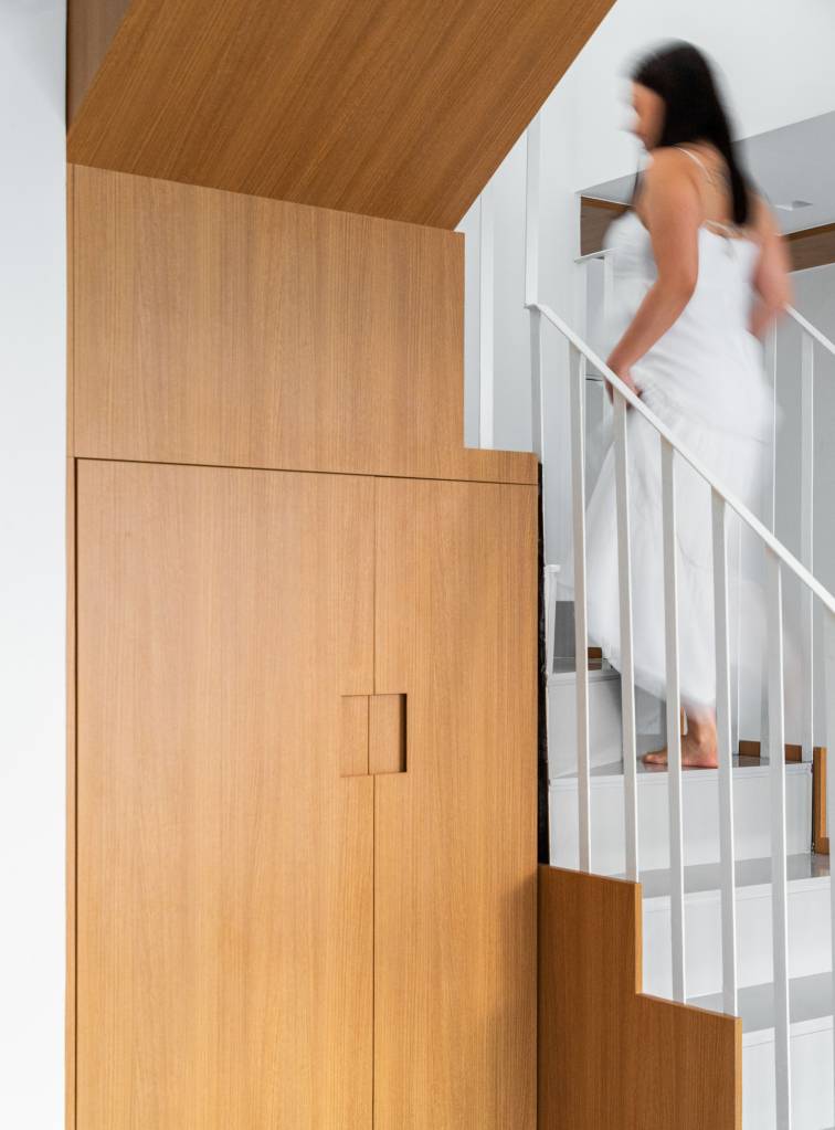 Escada de apê clean tem degraus e espelhos revestidos em quartzo cinza. Projeto de Rafael Ramos.